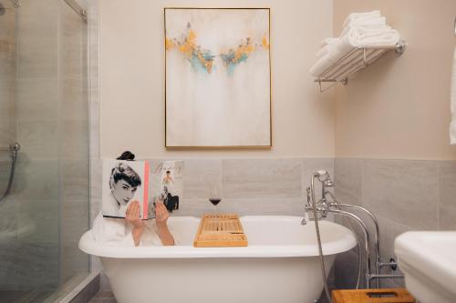 a bathroom with a bath tub with a picture on the wall at Hotel Winters in Winters