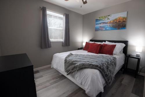 a bedroom with a large bed with red pillows at Luxurious 2-Bedroom Abode with Elevated Comforts Near Main Street in St. Charles