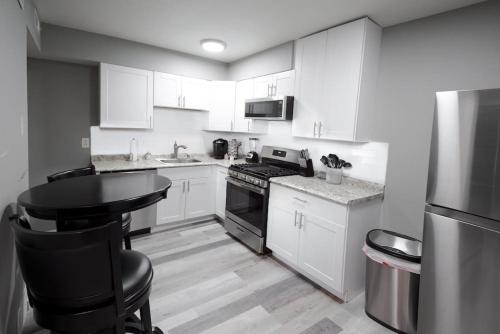 a kitchen with white cabinets and a black counter top at Luxurious 2-Bedroom Abode with Elevated Comforts Near Main Street in St. Charles