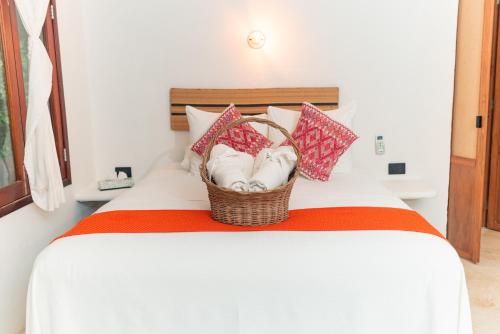 a basket of towels sitting on top of a bed at Casa Takywara in Holbox Island