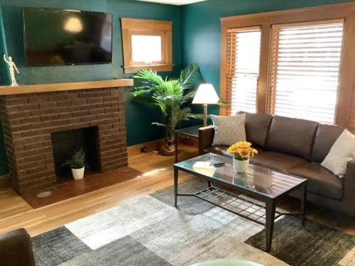 a living room with a couch and a fireplace at The House Hotels - Cohasset Lower in Lakewood