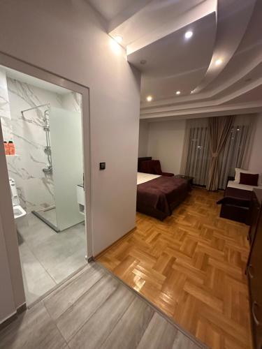 sypialnia z łóżkiem i drewnianą podłogą w obiekcie Hotel Real w Prisztinie