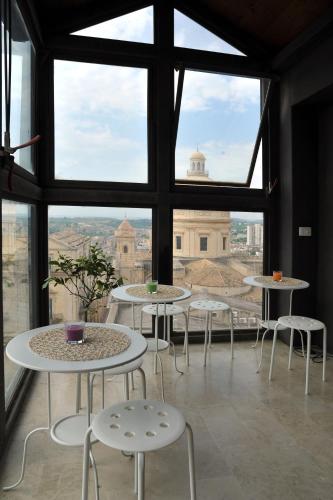 a room with tables and chairs and a large window at Ostello della Gioventù - Il Castello in Noto