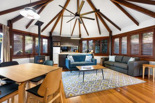 a living room with a table and a couch at Jandar Retreat Maleny in Maleny