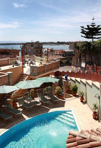 a swimming pool with chairs and umbrellas on a resort at Villa Cristina in Giardini Naxos