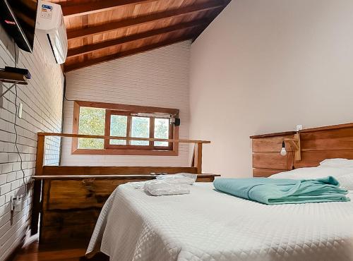 een slaapkamer met een bed en een raam bij Chale pe na areia c WIFI -Praia do Peixe Grande BA in Prado