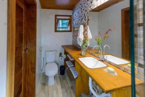 a bathroom with a sink and a toilet in it at Chale pe na areia c WIFI -Praia do Peixe Grande BA in Prado