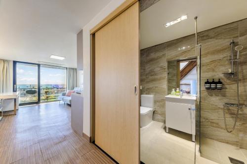 a bathroom with a shower and a toilet and a sink at IRO Jeju in Seogwipo