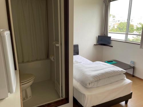 ein Schlafzimmer mit Bett und ein Badezimmer mit Spiegel in der Unterkunft Southern Village Okinawa - Vacation STAY 09974v in Kishaba