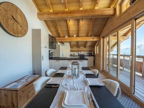 une longue salle à manger avec une grande horloge sur le mur dans l'établissement Appartement 3 pièces au centre de l'Alpe d'Huez avec WIFI - FR-1-645-44, à Huez