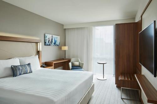 ein Hotelzimmer mit einem Bett und einem Flachbild-TV in der Unterkunft Courtyard by Marriott London City Airport in London