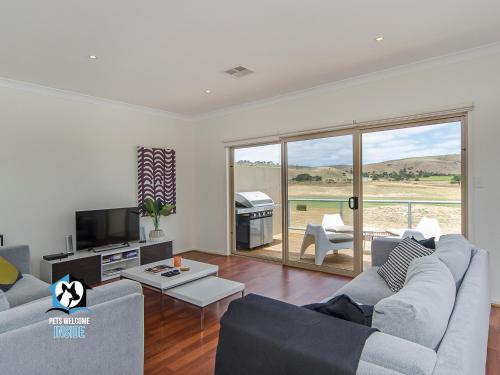 a living room with a couch and a television at Contemporary Golf Course Frontage 3BR in Normanville