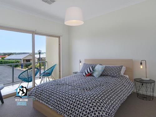 a bedroom with a bed and a large window at Contemporary Golf Course Frontage 3BR in Normanville