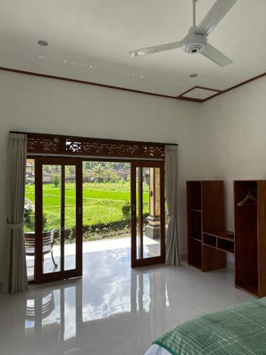 シデメンにあるThe babakan accommodationsのベッドルーム1室(ベッド1台付)、スライド式ガラスドアが備わります。