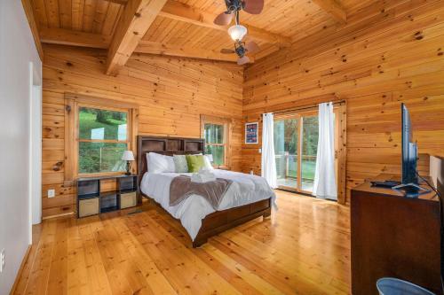 um quarto com uma cama num quarto com paredes de madeira em Panoramic Paradise 3BR Cabin with Idyllic Views 