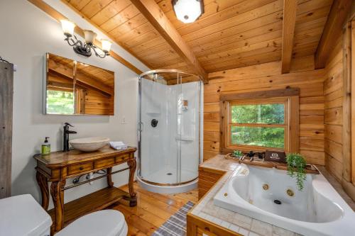 uma casa de banho com uma banheira e um chuveiro numa cabina em Panoramic Paradise 3BR Cabin with Idyllic Views 