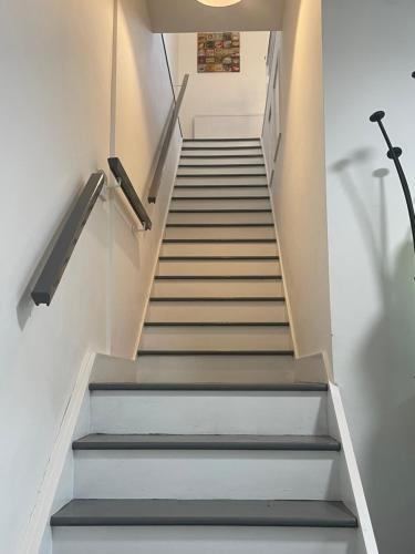 a staircase with grey steps and a light fixture at Bethel Apartments in Leeds