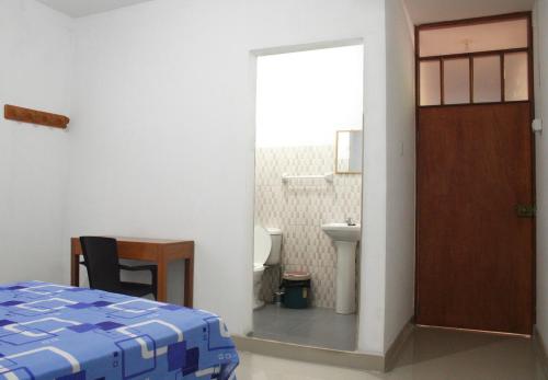 Habitación con cama y baño con aseo. en Casa Albina en Yurimaguas