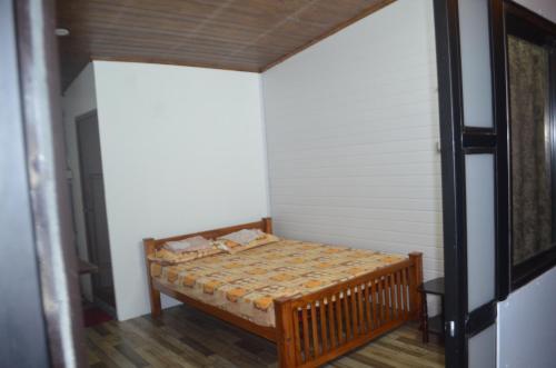 Habitación pequeña con cama en la esquina en The Meadows INN, en Kottayam