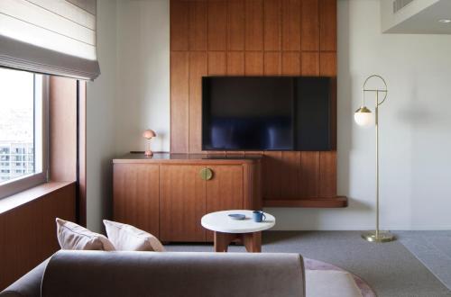 The Mark Grand Hotel في سايتاما: غرفة معيشة مع أريكة وتلفزيون بشاشة مسطحة