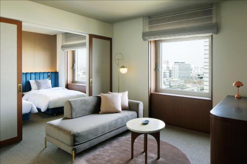 Habitación de hotel con sofá y cama en The Mark Grand Hotel, en Saitama