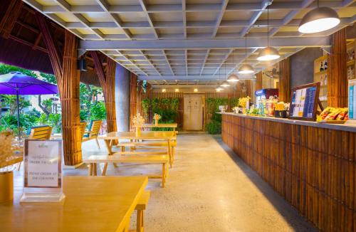 a restaurant with wooden tables and chairs and a bar at Avatar Danang Hotel in Da Nang