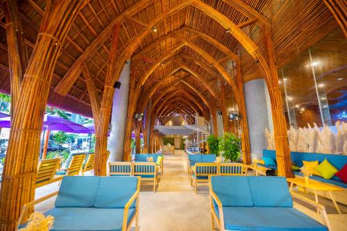a restaurant with blue chairs and tables and a wooden ceiling at Avatar Danang Hotel in Da Nang