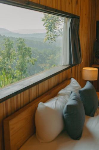 a room with a window and a bed with pillows at Lavender Dalat Hotel and Resorts in Da Lat