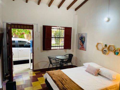 ein Schlafzimmer mit einem Bett, einem Tisch und einem Auto in der Unterkunft Apartaestudio Colonial, Aire Acondicionado, wifi 200 Mbps in Envigado