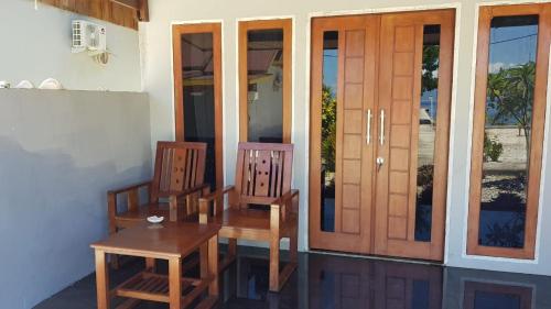 two chairs and a table in front of a house at Amoryg Resort and Dive Raja Ampat in Pulau Mansuar