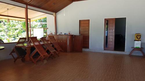 uma sala de jantar com uma mesa de madeira e cadeiras em Amoryg Resort and Dive Raja Ampat em Pulau Mansuar