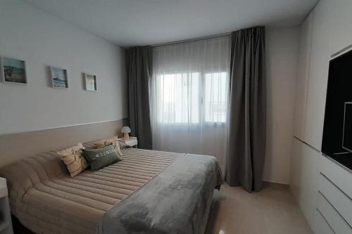 une chambre avec un grand lit et une fenêtre dans l'établissement Caleta View - Dpto Confortable, à Puerto Madryn