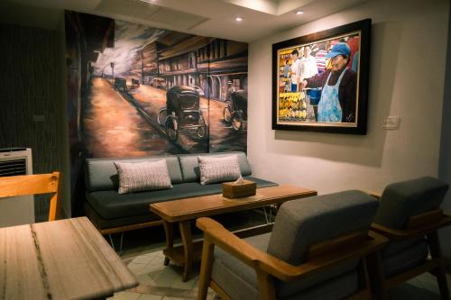 una sala de espera con sofá y una pintura en la pared en Sabai Sathorn Service Apartment en Bangkok