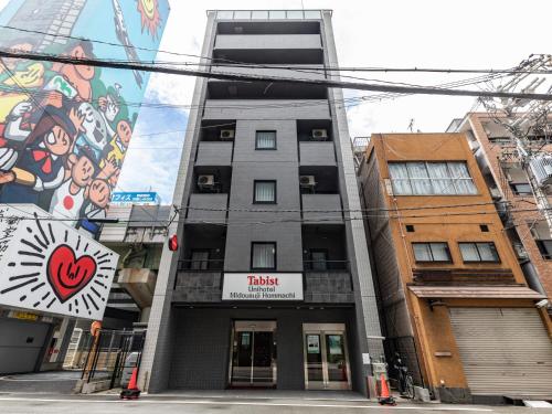 a building with a mural on the side of it at Tabist Unihotel Midosuji Hommachi in Osaka