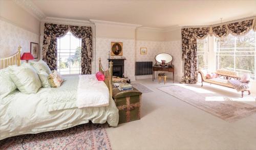 North Ormsby Manor في لاوث: غرفة نوم بسرير كبير ومدفأة