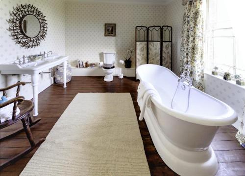 a white bathroom with a tub and a sink at North Ormsby Manor in Louth