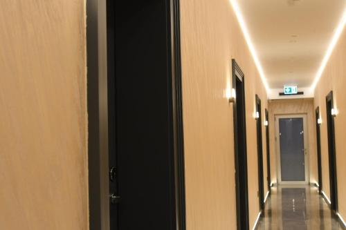 a hallway of a building with a door and lights at KAME HOTEL BELGRADE,贝尔格莱德凯美酒店 in Ledine