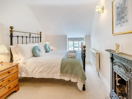 a bedroom with a large bed and a fireplace at Lavender Cottage in Helmsley