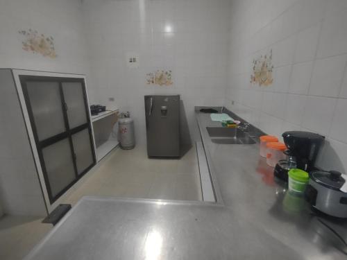 a kitchen with a sink and a refrigerator in a room at Acogedor apartamento en Buga in Buga