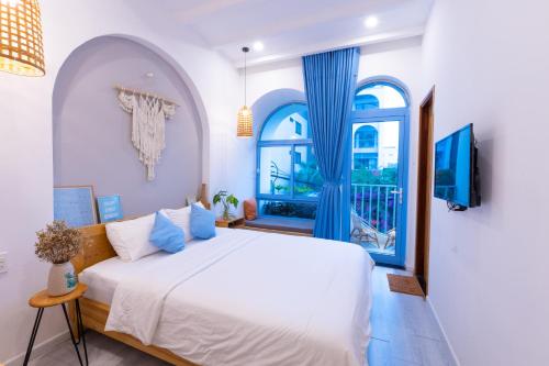a bedroom with a white bed and a window at Nest House Homestay in Danang