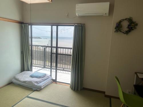 Zimmer mit einem großen Fenster und Meerblick in der Unterkunft 民宿たかはま Takahama Guest house 