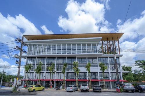 a building with cars parked in front of it at Tour De Phuket Hotel - SHA Plus in Thalang