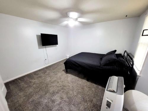 a bedroom with a bed and a flat screen tv at 4-Bedroom House Close to Beach in Salisbury