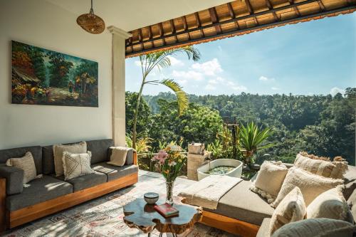 a living room with a couch and a table at Sunrise Villa in Payangan