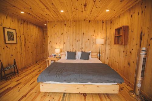 a bedroom with a bed in a wooden wall at Lavender Dalat Hotel and Resorts in Da Lat