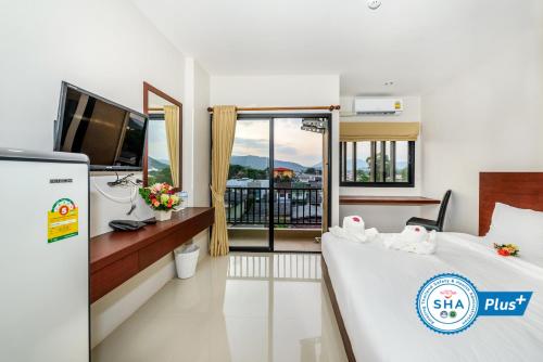 a hotel room with two beds and a tv at The Topaz Residence Phuket Town in Phuket Town