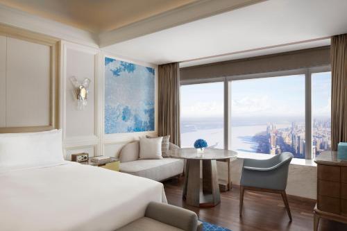 a hotel room with a bed and a large window at The Ritz-Carlton, Harbin in Harbin