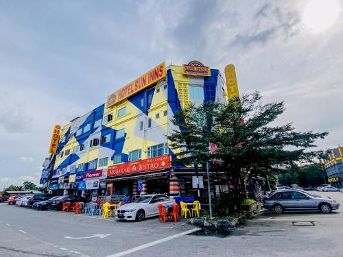 un edificio amarillo y azul con coches estacionados en un estacionamiento en Sun Inns Hotel Cheras - Balakong, en Cheras