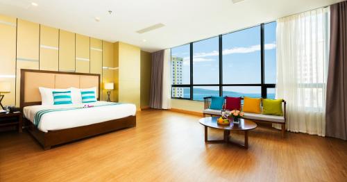 a bedroom with a bed and a couch and a table at Avatar Danang Hotel in Da Nang