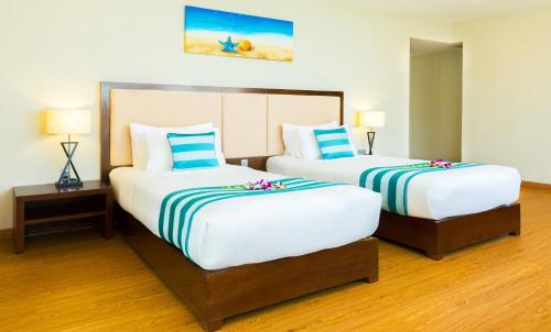 a hotel room with two beds with flowers on them at Avatar Danang Hotel in Da Nang